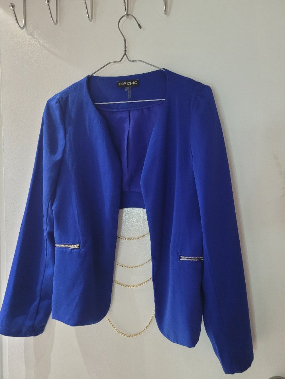 Womens blue blazer with open back and gold chains